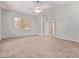 Spacious main bedroom featuring neutral color walls, carpet and large sunny window at 21373 N 94Th Ave, Peoria, AZ 85382