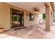 Covered patio with stone flooring overlooks the landscaped back yard at 21373 N 94Th Ave, Peoria, AZ 85382