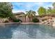 Relaxing pool with rock waterfall feature and block wall in the backyard at 21373 N 94Th Ave, Peoria, AZ 85382