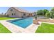 Relaxing backyard with a sparkling pool, lush artificial turf, and manicured landscaping at 21918 E Maya Rd, Queen Creek, AZ 85142