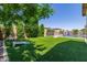 Lush backyard featuring artificial turf, a fenced pool, and mature landscaping for a private retreat at 21918 E Maya Rd, Queen Creek, AZ 85142