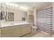 Well-lit bathroom with a large vanity, tile floors and striped shower curtain at 21918 E Maya Rd, Queen Creek, AZ 85142