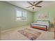 Light and airy bedroom features a ceiling fan, neutral carpet and a modern bed frame at 21918 E Maya Rd, Queen Creek, AZ 85142
