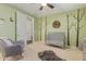 Neutral color bedroom with a window, ceiling fan, and a grey cushioned rocking chair at 21918 E Maya Rd, Queen Creek, AZ 85142