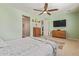 Comfortable bedroom offers a ceiling fan, wooden dresser and a tv at 21918 E Maya Rd, Queen Creek, AZ 85142