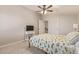 Bedroom with floral bedspread, white nightstand, TV and carpet floors at 21918 E Maya Rd, Queen Creek, AZ 85142