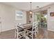 Cozy dining area with a rustic table, white chairs, and a sliding door to the backyard at 21918 E Maya Rd, Queen Creek, AZ 85142