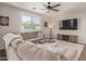 Bright living room with a plush sectional sofa, ceiling fan, and an inviting ottoman at 21918 E Maya Rd, Queen Creek, AZ 85142