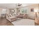 Inviting living room with a large sectional, ceiling fan, and a view into the dining area at 21918 E Maya Rd, Queen Creek, AZ 85142