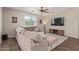 Comfortable living room featuring a large sectional couch and a ceiling fan for added comfort at 21918 E Maya Rd, Queen Creek, AZ 85142