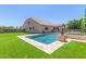 A backyard oasis features a sparkling pool, surrounded by lush greenery and a charming putting green at 21918 E Maya Rd, Queen Creek, AZ 85142