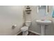Elegant powder room featuring a pedestal sink and modern wall decor at 21918 E Maya Rd, Queen Creek, AZ 85142