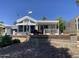 Charming home exterior featuring a well-maintained yard, covered porch, and architectural details at 2192 W Taos Ave, Apache Junction, AZ 85119