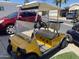This yellow golf cart with four wheels is parked outside at 2192 W Taos Ave, Apache Junction, AZ 85119