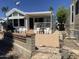 This white house has a patio with white furniture and a stone fence at 2192 W Taos Ave, Apache Junction, AZ 85119