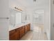 Bathroom with double sinks, expansive mirror, a wooden vanity and tile floors at 2206 S 114Th Ln, Avondale, AZ 85323