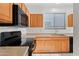 Well-equipped kitchen featuring wooden cabinetry and black appliances at 2206 S 114Th Ln, Avondale, AZ 85323