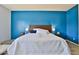 Main bedroom with a striking accent wall, a plush bed, and nightstands with lamps at 2221 W Madisen Marie Ave, Queen Creek, AZ 85144