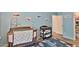 Cozy Bedroom with airplane decor, a wooden crib, and a changing table for convenience at 2221 W Madisen Marie Ave, Queen Creek, AZ 85144