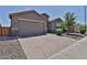 A cozy home with a brick-paved driveway and a two-car garage, nestled in a well-kept neighborhood at 2221 W Madisen Marie Ave, Queen Creek, AZ 85144