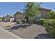Charming home with a well-maintained yard, featuring a gravel landscape, mature trees, and trimmed shrubs at 2221 W Madisen Marie Ave, Queen Creek, AZ 85144
