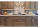 Modern kitchen featuring sleek countertops, a gas cooktop, and a stainless steel range hood at 2221 W Madisen Marie Ave, Queen Creek, AZ 85144