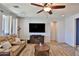 Inviting living room with a ceiling fan, a comfortable couch, and a modern entertainment center at 2221 W Madisen Marie Ave, Queen Creek, AZ 85144