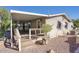 Manufactured home exterior featuring a covered deck with stairs and desert landscaping at 2233 E Behrend Dr # 84, Phoenix, AZ 85024