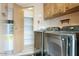 Functional laundry room featuring modern washer and dryer units with shelving for storage at 2233 E Behrend Dr # 84, Phoenix, AZ 85024