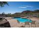 Relaxing community pool area with seating, mature landscaping, and views of the nearby mountains at 2233 E Behrend Dr # 84, Phoenix, AZ 85024