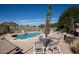 Community pool surrounded by lounge chairs, tables, and umbrellas on a sunny day at 2233 E Behrend Dr # 84, Phoenix, AZ 85024