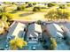 Aerial view of a home with manicured lawn in a community featuring a serene pond and lush green spaces at 2412 W Camp River Rd, San Tan Valley, AZ 85144