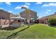 Backyard features a well-manicured lawn, palm tree, and a covered hot tub on a sunny day at 2412 W Camp River Rd, San Tan Valley, AZ 85144