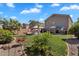 Landscaped backyard featuring green lawn, mature plants, BBQ, and patio furniture under a bright blue sky with some white clouds at 2412 W Camp River Rd, San Tan Valley, AZ 85144