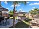 Backyard shows a hot tub under a gazebo, outdoor chairs, palm trees, and blue skies at 2412 W Camp River Rd, San Tan Valley, AZ 85144