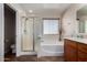 Bathroom featuring a shower with glass doors, a tub, and a sink with cabinet at 24806 W Hidalgo Dr, Buckeye, AZ 85326
