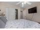 Well-lit bedroom with wood floors and a closet, featuring a comfortable bed and a ceiling fan at 24806 W Hidalgo Dr, Buckeye, AZ 85326