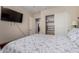 Well-lit bedroom featuring a TV, an open closet, and neutral-toned walls at 24806 W Hidalgo Dr, Buckeye, AZ 85326