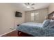 Bedroom featuring hardwood floors, a ceiling fan, a television, and a comfortable bed at 24806 W Hidalgo Dr, Buckeye, AZ 85326