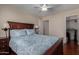 Inviting bedroom featuring wood floors, a ceiling fan, closet, and a queen bed with a stylish pattern at 24806 W Hidalgo Dr, Buckeye, AZ 85326