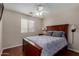 Well-lit bedroom features a ceiling fan, window, wood floors, and a comfortable bed at 24806 W Hidalgo Dr, Buckeye, AZ 85326
