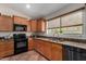 Efficient kitchen with stainless steel sink, wood cabinets, and granite counters for a modern aesthetic at 24806 W Hidalgo Dr, Buckeye, AZ 85326