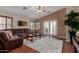 Inviting living room features a comfortable brown sectional, vaulted ceiling, and access to the backyard at 24806 W Hidalgo Dr, Buckeye, AZ 85326