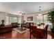 Spacious living room with hardwood floors, fan, and an open layout that connects to the dining area at 24806 W Hidalgo Dr, Buckeye, AZ 85326