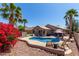 Backyard pool with lounge chairs, patio umbrella, barbecue, and blooming bougainvillea at 24806 W Hidalgo Dr, Buckeye, AZ 85326