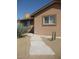 A charming tan-colored home features decorative gravel, native plants and a flagstone walkway at 27239 N 64Th Way, Scottsdale, AZ 85266