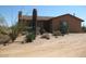 A charming tan-colored home is complemented by native desert plants and gravel landscaping at 27239 N 64Th Way, Scottsdale, AZ 85266