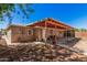 Covered back patio of a house with an open beam wood awning, concrete floor, and chairs at 2750 W Turney Ave, Phoenix, AZ 85017