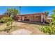 Open back patio area with a light colored floor and wooden awning attached to a house with grass and trees at 2750 W Turney Ave, Phoenix, AZ 85017