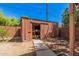 Backyard shed with a concrete walkway in a yard surrounded by a brick fence, and trees at 2750 W Turney Ave, Phoenix, AZ 85017